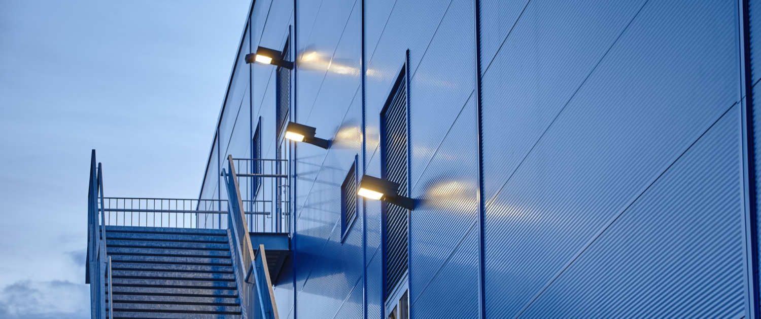 Lamp posts mounted on blue warehouse with fire escape Sondersituationen