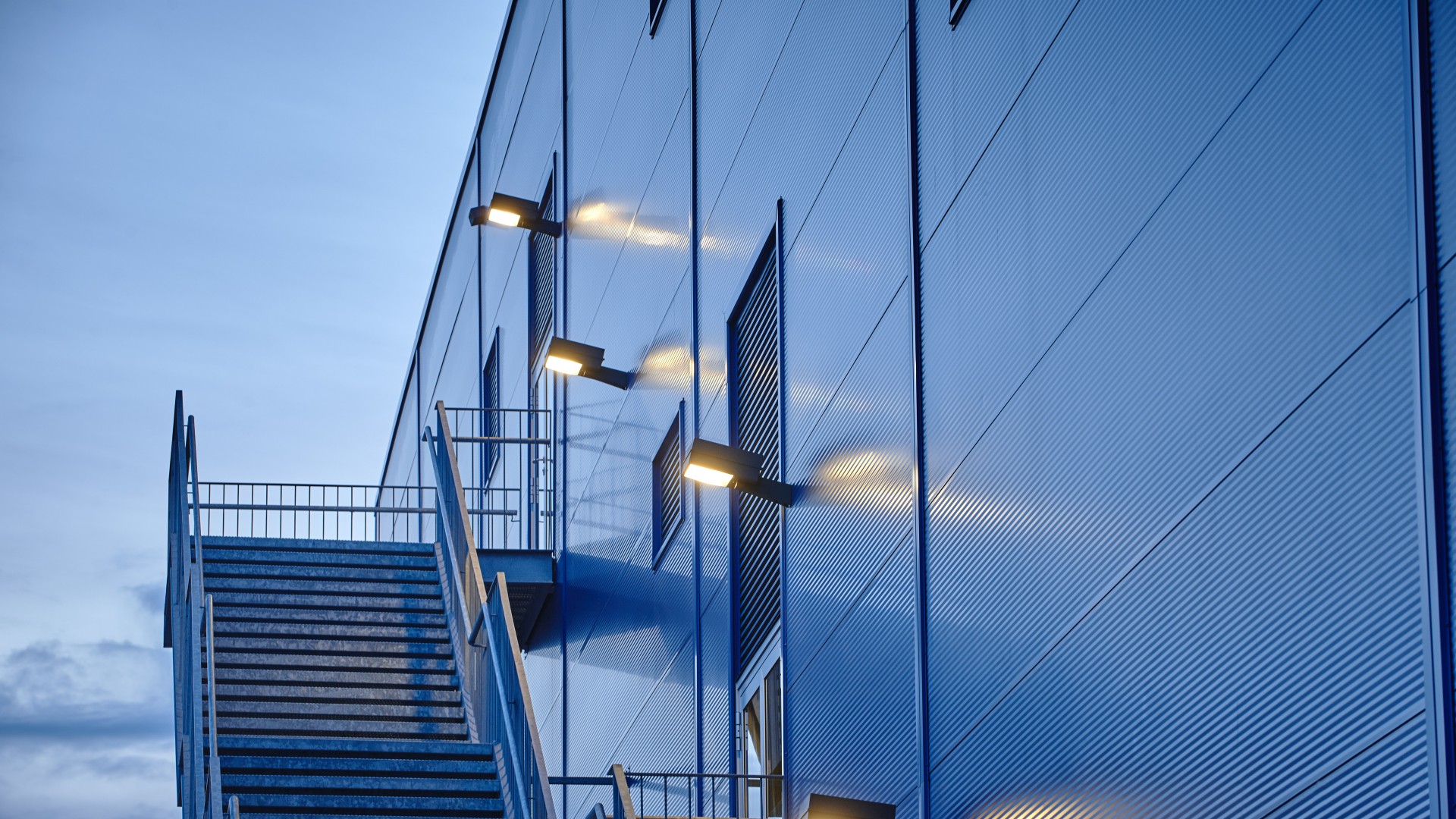 Lamp posts mounted on blue warehouse with fire escape Sondersituationen